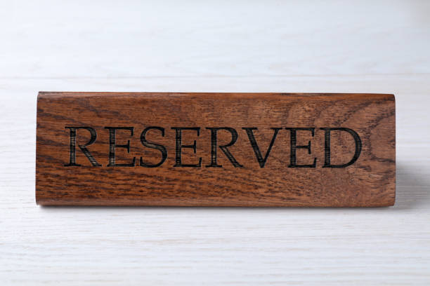 istock Elegant wooden sign RESERVED on white table 1451733827