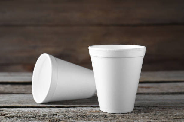 istock Two white styrofoam cups on wooden table, closeup 1451734114
