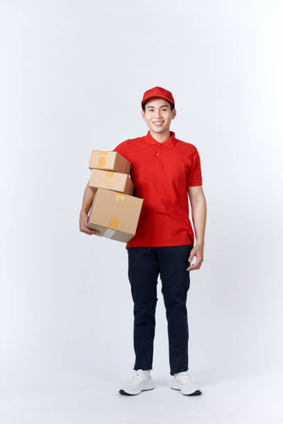 istock Young man holding delivery package looking positive and happy standing and smiling 1451744497