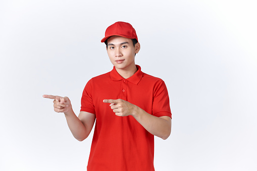 Photo of funny  guy indicate forefingers empty space wear red t-shirt cap isolated white background