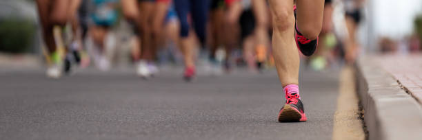 maratoneti che corrono su strada in città - maratona foto e immagini stock