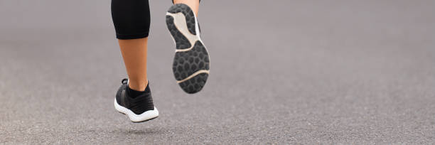 istock Athlete runner feet running on road close up on shoe 1451748135