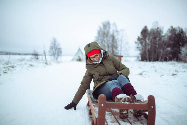 istock A cheerful woman is having fun sledding 1451749659