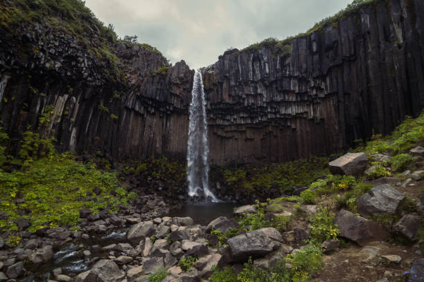 istock Narrow waterfall on high cliff landscape photo 1451752951