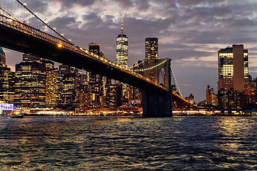 New York City skyline at night with Brooklyn Bridge and Lower Manhattan. Image shot from Brooklyn.