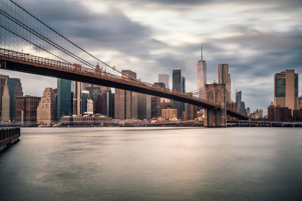 Brooklyn Bridge and Manhattan skyline at sunset on a cloudy day stock photo