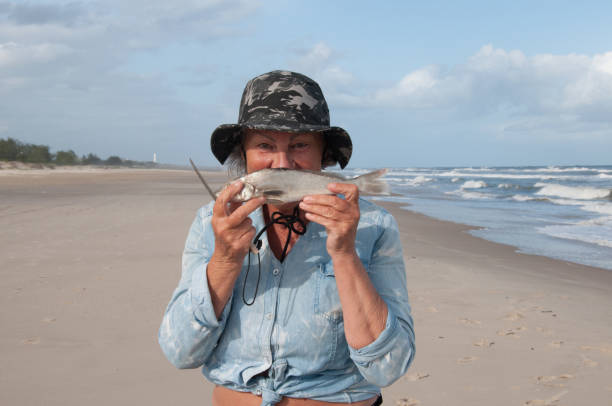 Old lady fishing on the beach in brazil