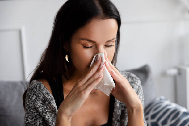 istock Sick woman blowing her nose 1451767998