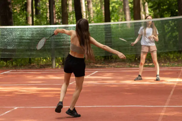 Photo of badminton outdoor, two girls play in the park in nature, sports and recreation