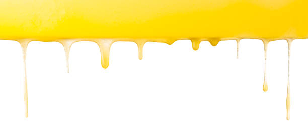 istock Dripping yellow liquid or oil on a white background, wide. 1451771309