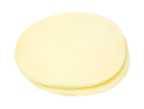 A side view of three slices of provolone cheese stacked on a white background.