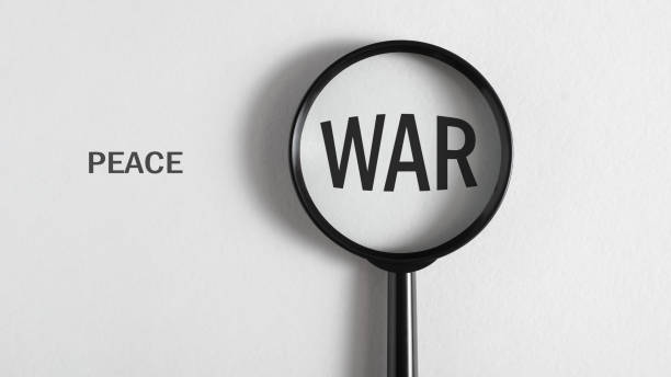 istock Peace and war concept. Magnifier focused on word war on white background, top view 1451781158