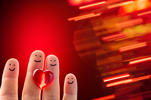 Happy finger people with a red heart on a defocused lines background. Space for copy.