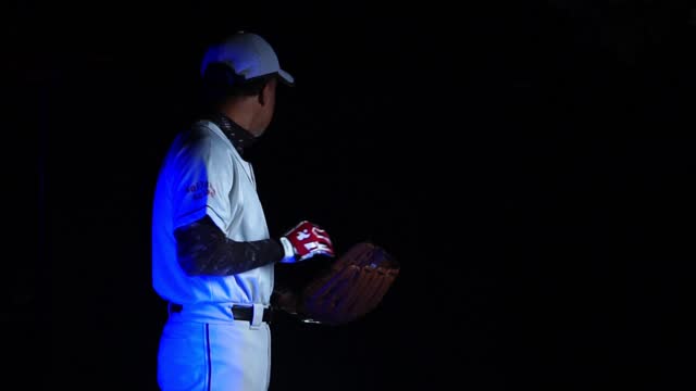 A baseball player pitcher with his baseball and baseball gloves