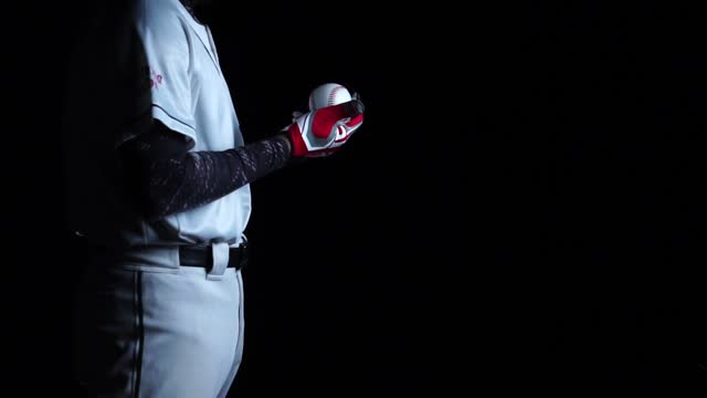 A baseball player pitcher with his baseball and baseball gloves