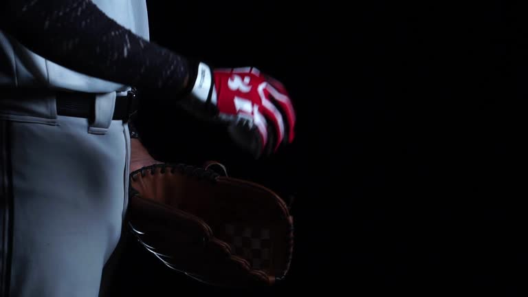 A baseball player pitcher with his baseball and baseball gloves