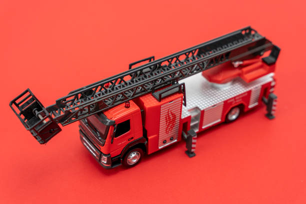 istock toy fire truck on a red background. Emergency vehicle 1451798566