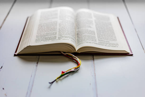 istock Open holy bible on white wooden surface 1451799645