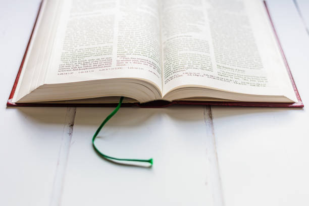 istock Open holy bible on white wooden surface 1451799646
