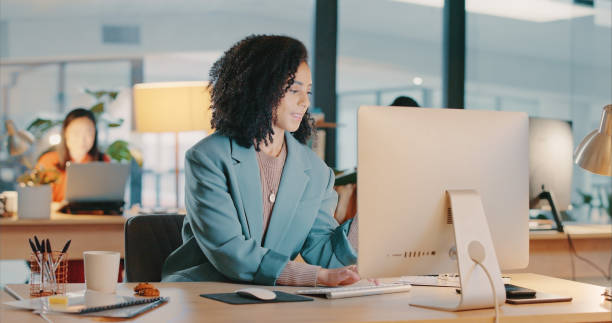 mujer negra de negocios, computadora y escritorio de oficina en una agencia de marketing digital mecanografiando, escribiendo o investigando la estrategia de redacción publicitaria. editor, diseño y edición corporativa de mujeres en escritorio en el sit - corrector redactor fotografías e imágenes de stock