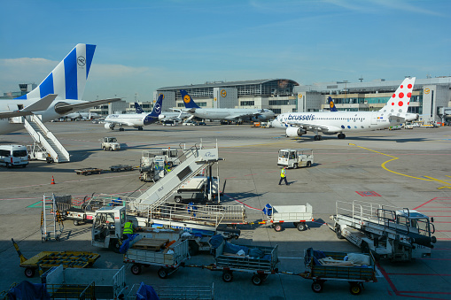 Frankfurt Airport Germany August 02, 2022 - Airplanes and some luggage trolleys at the terminal