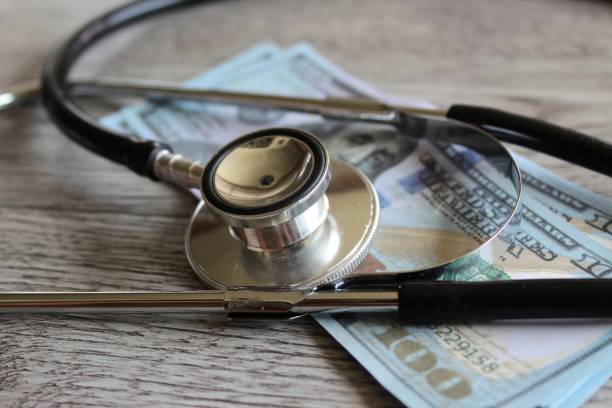 istock Stethoscope and money on wooden table. 1451804141
