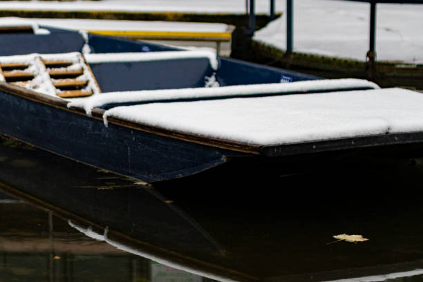 Old rowing boat at the lakeshore with ice in the lake