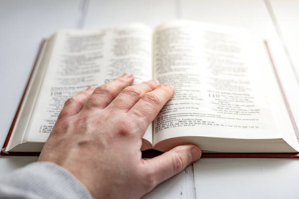 istock Hand resting on pages of holy bible 1451806990