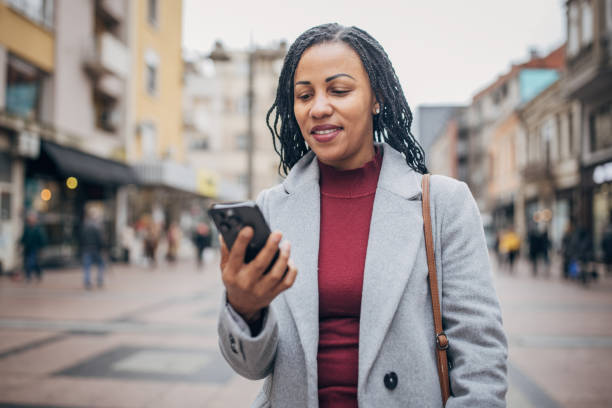istock Woman using smart phone on the street 1451812917