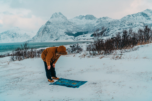 A Muslim traveling through arctic cold regions while performing the Muslim prayer namaz during breaks.