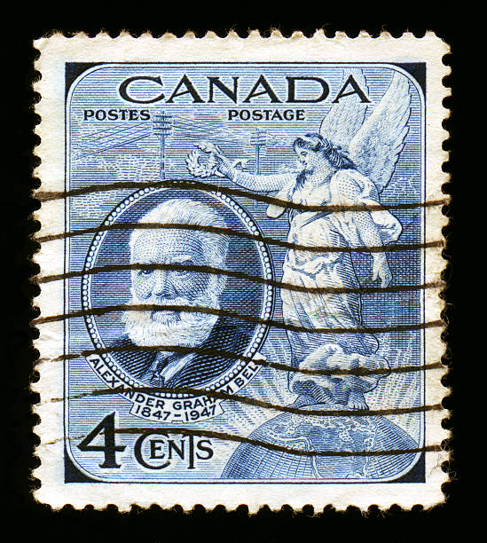 Canada Postage: Alexander Graham Bell 1947 Canadian Postage stamp honoring Alexander Graham Bell. Grahams profile is pictures with a classically styled Angel holding Laurel leaves above it while standing upon a globe of the world. Blue, engraved. alexander graham bell stock pictures, royalty-free photos & images