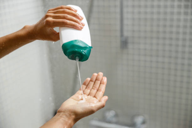 mujer vertiendo gel de ducha en su mano al tomar la ducha. concepto de higiene - shower gel fotografías e imágenes de stock