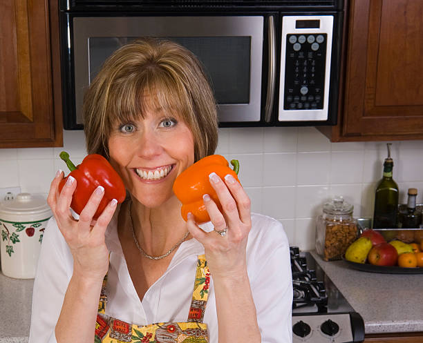 Woman in Kitchen with Peppers stock photo