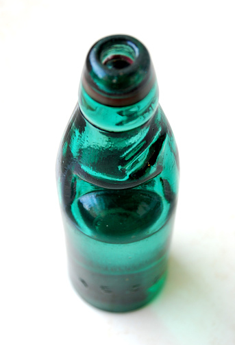 This is the photo of the traditional Indian (Country: India) sparkling water bottle. The carbonated water is   sealed with a marble (glass ball). It is opened by pressing the ball down. Taken using Nikon D80.