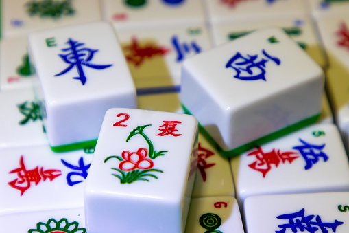 chinese new year concept - close up of asian family hands play mahjong at home