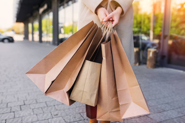 istock hand holds brown eco-friendly craft paper bag. 1451849176
