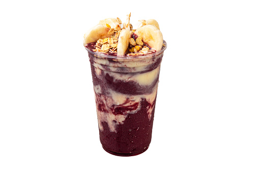 Brazilian acai with banana and granola in plastic cup.