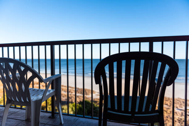 istock Seascape view through balcony railing with two chairs at Myrtle Beach resort hotel condo condominium apartment waterfront building, South Carolina 1451852597