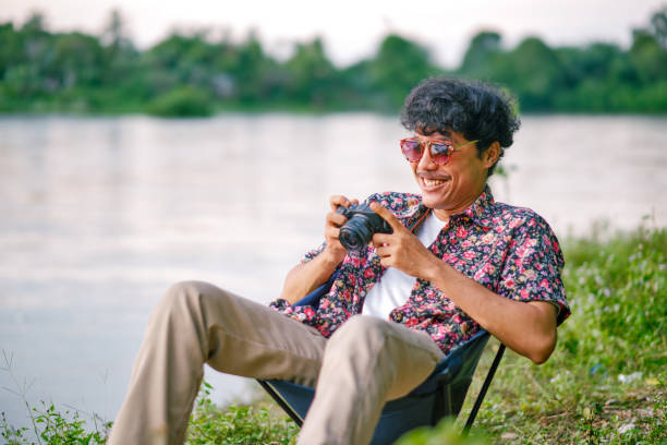 Young Adult sitting on river and looking at camera at sunset