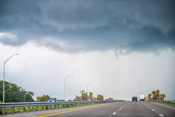 interstate highway road 95 i95 near daytona beach, florida with cars traffic by storm stormy gray blue clouds cloudy cloud cover - florida weather urban scene dramatic sky imagens e fotografias de stock