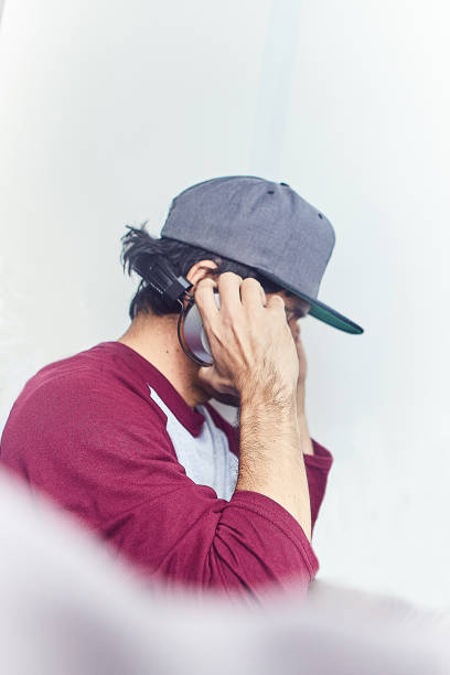 homem com fones de ouvido - men baseball cap focus determination - fotografias e filmes do acervo