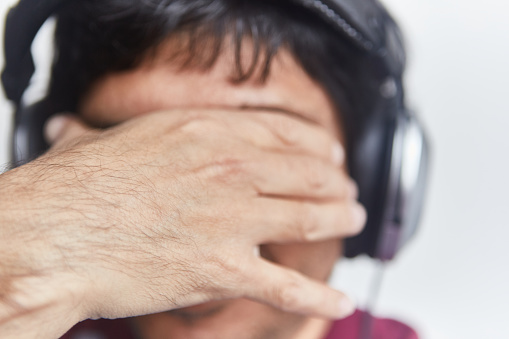 Shot of a frustrated man wearing headphones