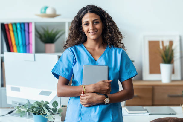 istock Female nurse using her digital tablet while standing in the consultation. 1451855165