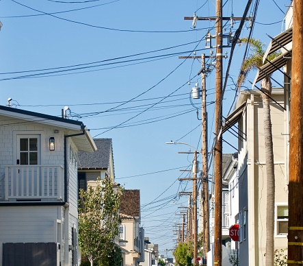 Row of Tangled power lines and street lights in the back alley