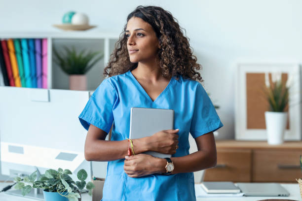 istock Female nurse using her digital tablet while standing in the consultation. 1451855298