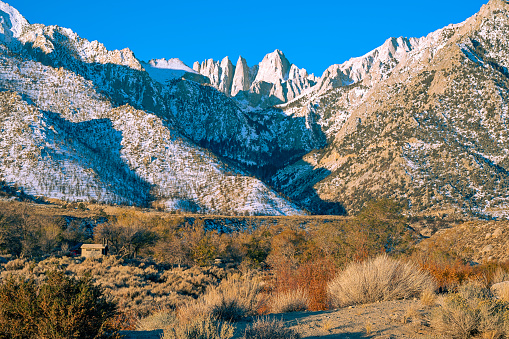 Early morning at snow capped Mt. Whitney in the Eastern Sierras in California. Mt. Whitney is the highest mountain in the contiguous United States and the Sierra Nevada, with an elevation of 14,505 feet.