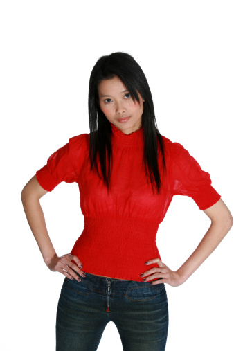 young Asian woman wearing a bright red blouse with her hands on her hips 