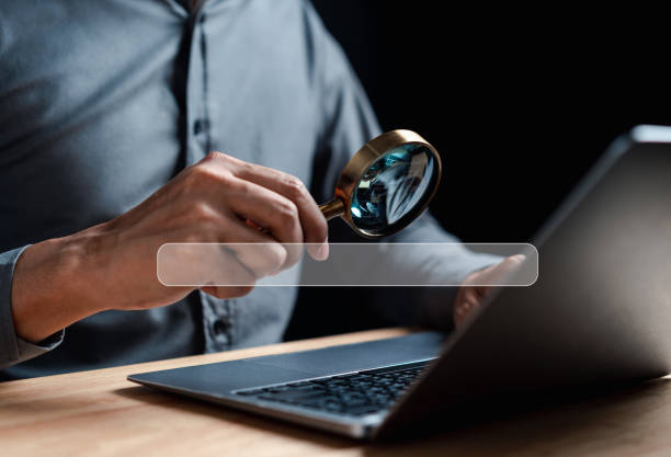 istock Businessman use magnifying glass Search On Virtual Screen Data Search Technology Search Engine Optimization. Man use computer to Searching for information. Using Search Console for data. 1451864621