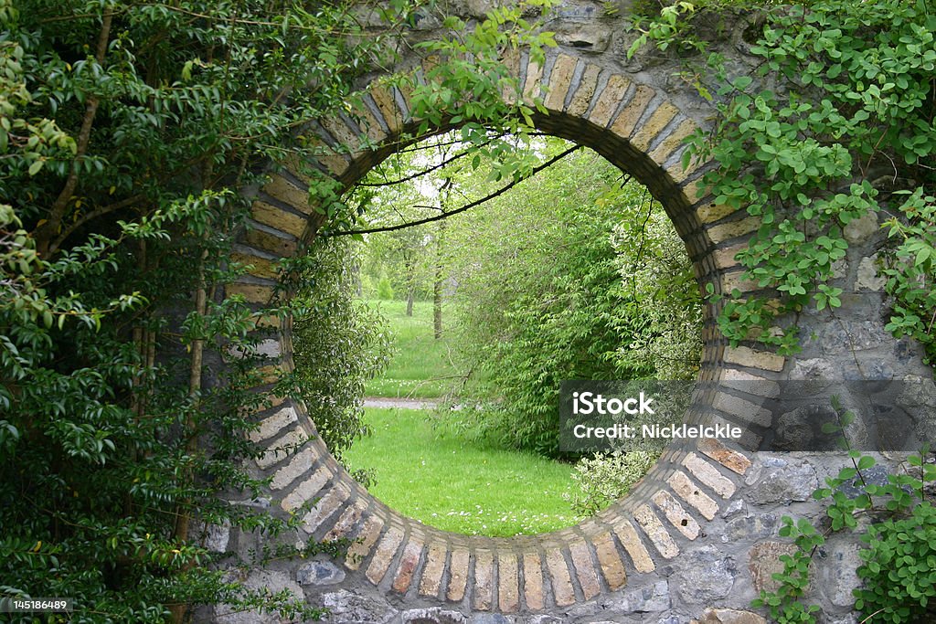 Secret Garden Round hole in a brick wall showing trees Mystery Stock Photo