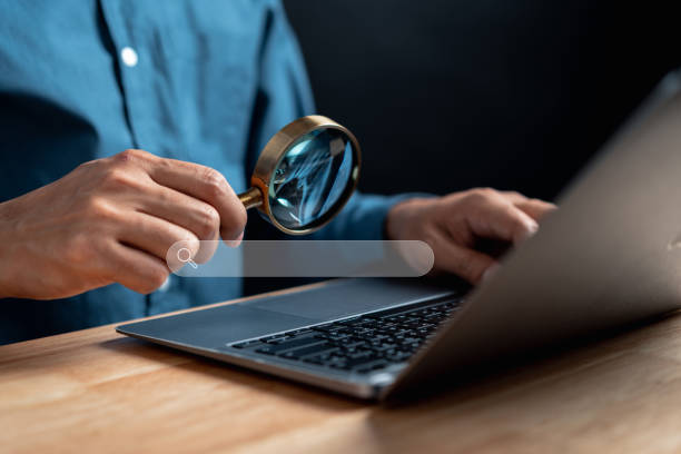 istock Businessman use magnifying glass Search On Virtual Screen Data Search Technology Search Engine Optimization. Man use computer to Searching for information. Using Search Console for data. 1451865875